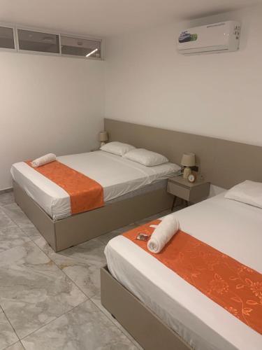 two beds in a room with two beds sidx sidx sidx at Hostal D'Marv in Manta