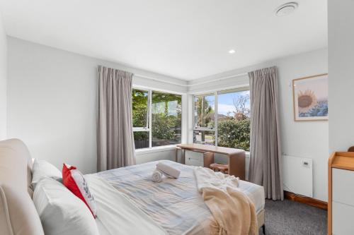 a bedroom with a bed and a window at Peaceful four bedroom holiday house near airport in Christchurch