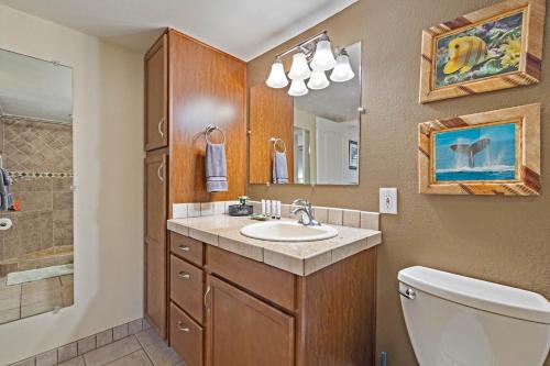 a bathroom with a sink and a toilet and a mirror at Maalaea Kai 110 Spectacular View in Paradise in Wailuku