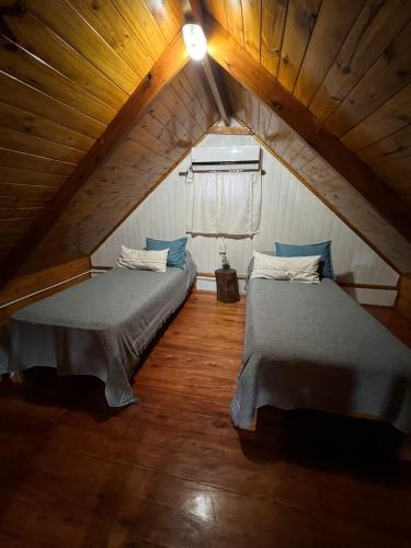 a attic room with two beds and a window at Miraflores Relax & Pool in Miramar