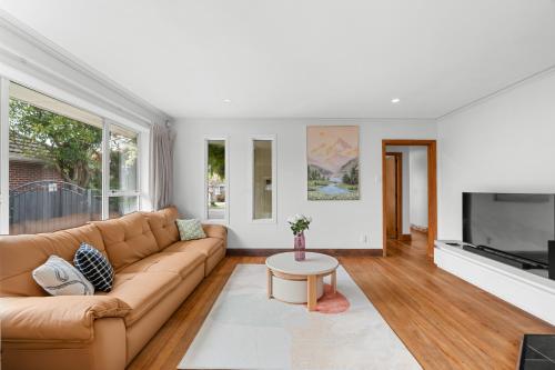 a living room with a couch and a table at Peaceful four bedroom holiday house near airport in Christchurch