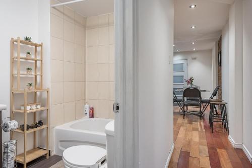 a bathroom with a tub and a toilet and a sink at Spacious 2BR Downtown - Vintage Charm Sleeps 10 in Montréal