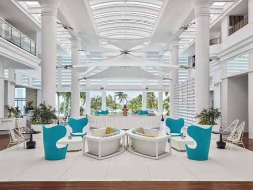 a lobby with blue and white chairs in a building at Mövenpick Hotel Mactan Island Cebu in Mactan
