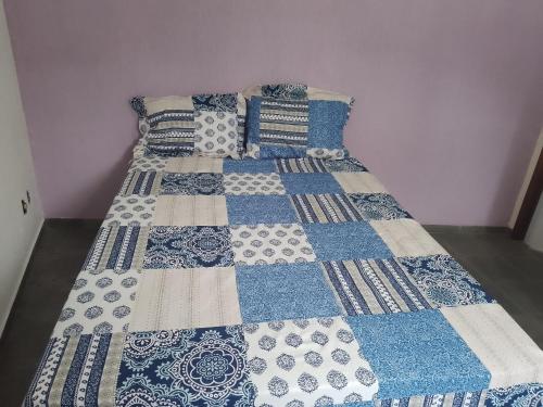 Una cama con un edredón azul y blanco. en Casa Aconchegante em Miguel Pereira, en Miguel Pereira