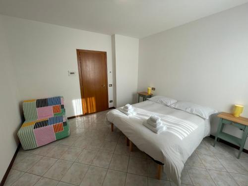 a white bedroom with a bed and a chair at Albergaria 