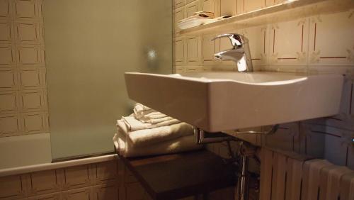 y baño con lavabo, espejo y toallas. en Hostal Miryam, en L'Escala