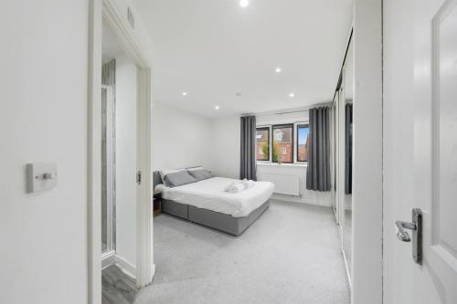 a white room with a bed and a window at Lara's 4 Bedroom House near Coventry in Coventry