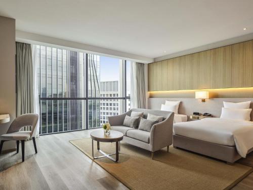 Una habitación de hotel con una cama y una ventana grande. en Novotel Shanghai Qingpu Excellence, en Shanghái