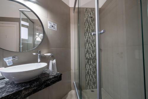 ein Badezimmer mit Waschbecken und Glasdusche in der Unterkunft HOTEL REGIS in Buenos Aires