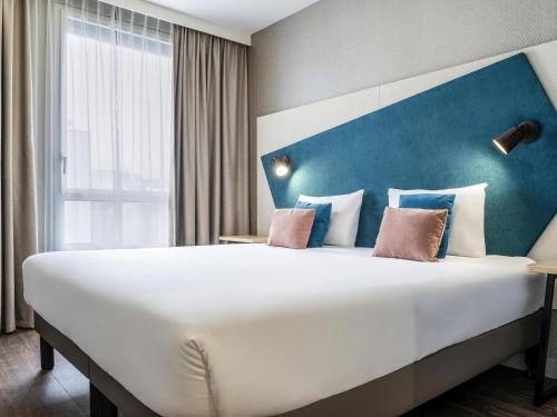 Ένα ή περισσότερα κρεβάτια σε δωμάτιο στο Aparthotel Adagio Paris Suresnes Longchamp