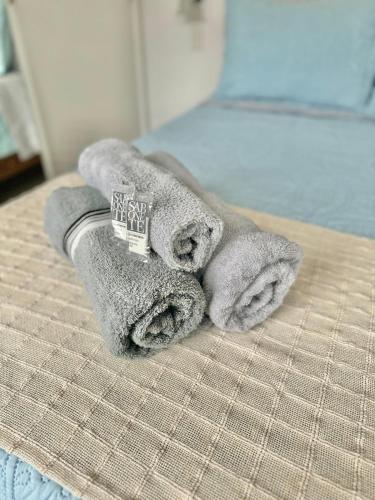 a pile of towels sitting on top of a bed at Apartamento com piscina em Olaria in Nova Friburgo