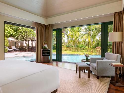 a bedroom with a large bed and a pool at Raffles Hainan Clear Water Bay in Sanya