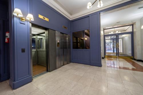 un corridoio vuoto con pareti blu e porte di vetro di HOTEL REGIS a Buenos Aires