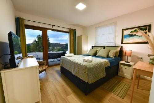 une chambre avec un lit et une grande fenêtre dans l'établissement Villa Jelena, à Donji Velemerić