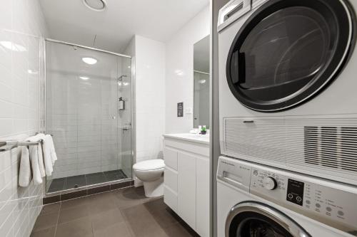 y baño con aseo, lavadora y secadora. en Quest Campbelltown, en Campbelltown