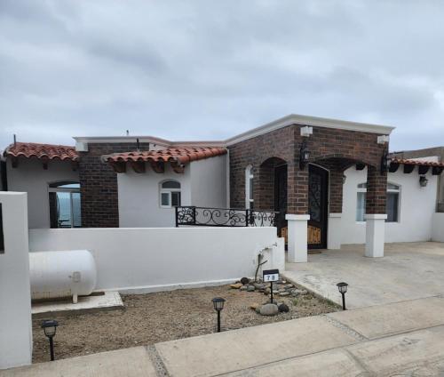 a house with a white fence in front of it at Baja Beach House Beautiful House Plaza del Mar in Primo Tapia