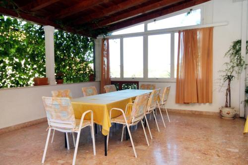 a dining room with a yellow table and chairs at Studio Vrboska 540a in Vrboska