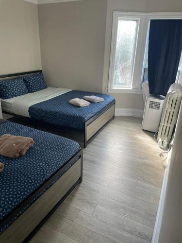 a room with two beds and a window at THE BLOOR AC SUITE-Free Wifi-Train-Bus Stop Next Door in Toronto