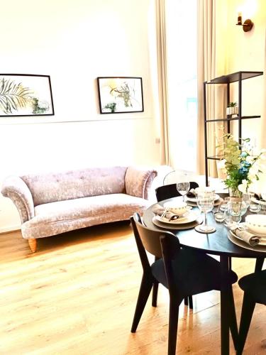 a living room with a table and a couch at One Bedroom Flat B in Kentish Town in London