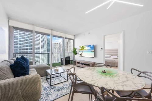 Una sala de estar con un sofá y una mesa con sillas. en Penthouse ICON W Hotel WaterViews Balcony Brickell, en Miami