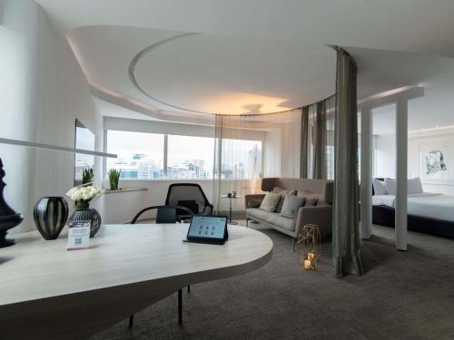a hotel room with a bed and a table with a laptop at Pullman Sao Paulo Vila Olimpia in Sao Paulo