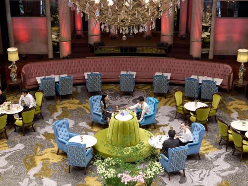 a group of people sitting at tables in a restaurant at Grand Mercure Imperial Palace Seoul Gangnam in Seoul
