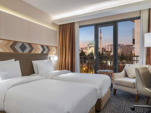a hotel room with two beds and a window at Mercure Ankara Kızılay in Ankara
