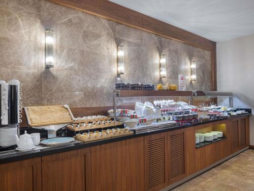 アンカラにあるMercure Ankara Kızılayのレストランのビュッフェラインで食べ物を注文する