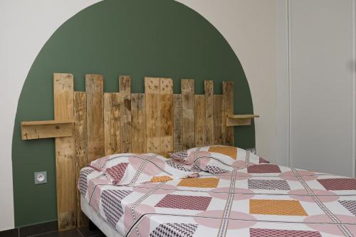 Un dormitorio con una cama con cabecero de madera. en Cocon Montabo - logement tout équipé avec climatisation et Wi-Fi - à seulement 5 min de la plage, en Cayenne