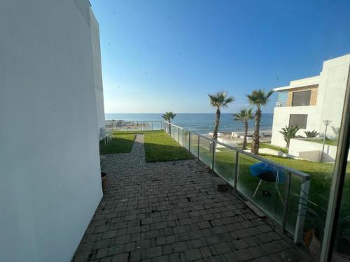 a balcony with a view of the beach at Luxurious Seaside Apartment in Sidi Bouqnadel