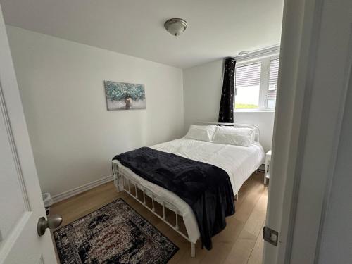 a small bedroom with a bed and a window at City View Charm St John's 1br, 8min To Downtown in Port Rexton