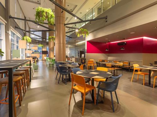Un comedor con mesas y sillas en un restaurante. en Mercure Jundiai Shopping, en Jundiaí