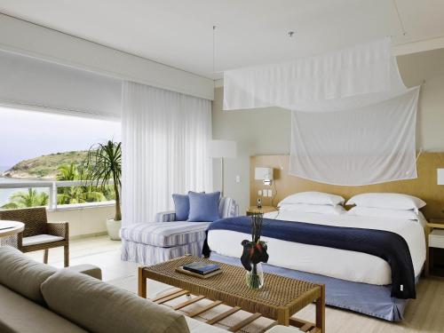 a bedroom with a large bed and a living room at Hotel Jequitimar Guaruja Resort & Spa by Accor - Ex Sofitel in Guarujá