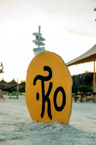 a yellow sign with the number k in the water at Tekio Beach Hotel in Holbox Island