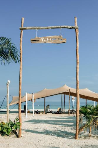 an empty beach with umbrellas and the ocean at Tekio Beach Hotel in Holbox Island