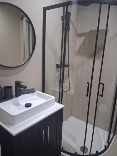 a bathroom with a shower and a sink and a mirror at 3 Bed Penthouse, 2Free Parking Spaces Close to BHX NEC in Birmingham
