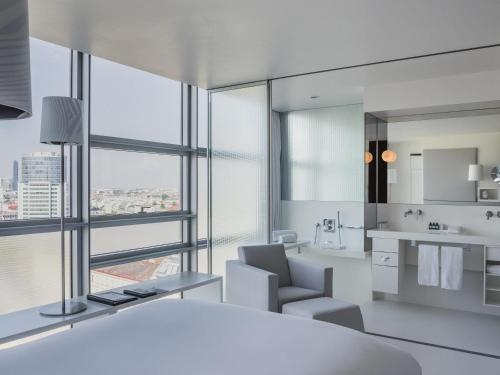 a white bathroom with a view of a city at SO/ Vienna in Vienna