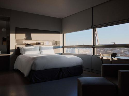 a bedroom with a large bed and a large window at SO/ Vienna in Vienna
