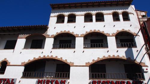 
a large white building with a large window at Hostal Miryam in L'Escala
