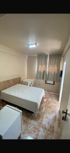 a bedroom with a large white bed in a room at Hotel Gerais Business in Montes Claros