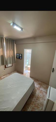 a bedroom with a large white bed in it at Hotel Gerais Business in Montes Claros