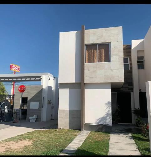 a building with a stop sign next to a gas station at Excelente hogar para descansar in Gómez