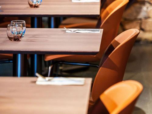 a row of tables and chairs with glasses on them at Mantra Terrace Brisbane in Brisbane