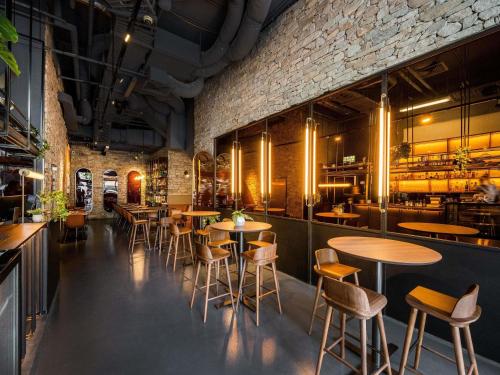a restaurant with tables and chairs and a brick wall at Mantra Terrace Brisbane in Brisbane