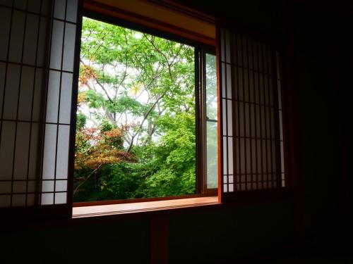 an open window with a view of a tree at パーパスリゾート EG Sky terrace 熱川 in Higashiizu