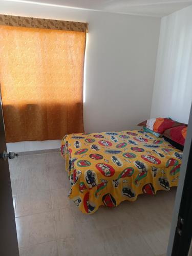 a bedroom with a bed with a colorful comforter at Excelente hogar para descansar in Gómez