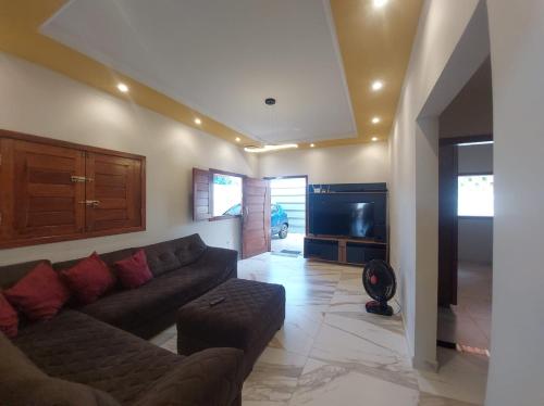 a living room with a couch and a flat screen tv at Casa Mineira in Nova Viçosa