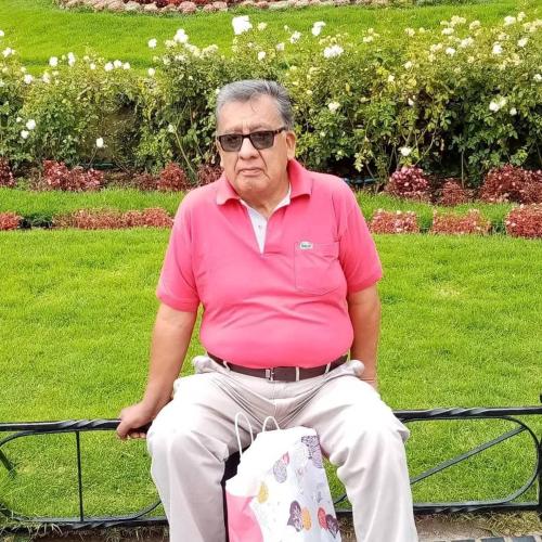 ポトシにあるCarのバッグを持ってベンチに座っている年配の男性