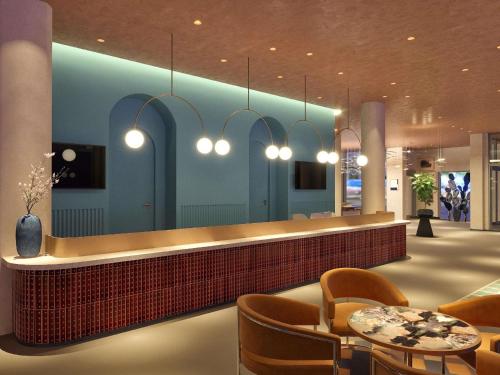 a lobby with a reception counter and chairs and lights at Hotel Lycium Debrecen - Handwritten Collection (October 2025) in Debrecen