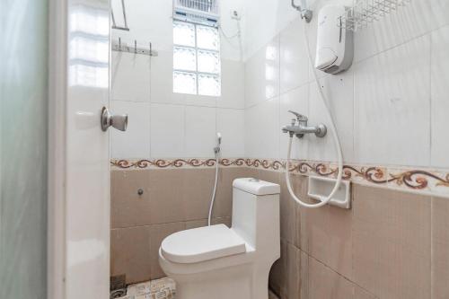 a white bathroom with a toilet and a shower at Wisma Vandera Syariah Garut Mitra RedDoorz in Garut